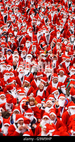 Centinaia di persone indossano abiti Santa per partecipare alla Great Scottish Santa Run, nei Princes Street Gardens di Edimburgo. Foto Stock