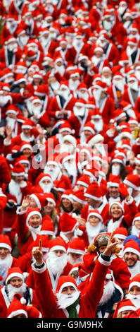 Centinaia di persone indossano abiti Santa per partecipare alla Great Scottish Santa Run, nei Princes Street Gardens di Edimburgo. Foto Stock