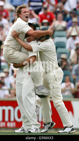 L'australiano Shane Warne (a sinistra) festeggia con Andrew Symonds (al centro) dopo aver preso il wicket finale del britannico Monty Panesar per vincere il quinto giorno del terzo Test match al WACA, Perth, Australia. Foto Stock