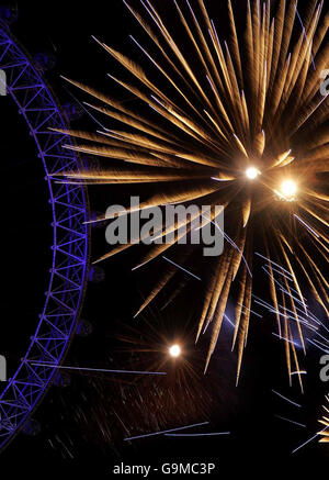 Il London Eye è illuminato da fuochi d'artificio per le celebrazioni del capodanno di Londra. Foto Stock