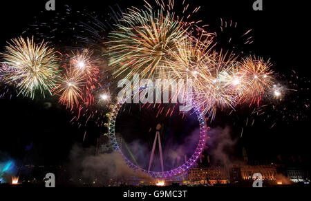 Il London Eye è illuminato da fuochi d'artificio per le celebrazioni del capodanno di Londra. Foto Stock