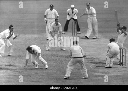 Cricket - The Ashes - primo test - Australia / Inghilterra - The Gabba - Fifth Day. L'Australia Richie Benaud (seconda l) intraprende un'azione evasiva mentre l'Inghilterra Trevor Bailey (r) tenta di spazzare una palla da Ian Johnson (terza r) Foto Stock