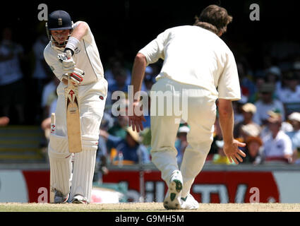 Il blocco Ian Bell dell'Inghilterra gioca un colpo contro il Glenn McGrath dell'Australia durante il terzo giorno della prima partita di prova al Gabba, Brisbane, Australia. Foto Stock