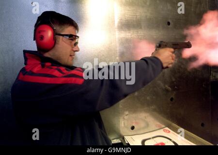 Le fiamme fuoriuscito dal muso della pistola utilizzata da ben Cohen dei Lions britannici, mentre alcuni membri del team Lions trascorrono la giornata nella galleria di tiro Lone Ranger a Perth Foto Stock