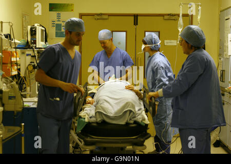 Il personale della sala operatoria prepara un paziente per una resezione anteriore laparoscopica su un paziente presso il Royal Hampshire County Hospital di Winchester, Hampshire. Foto Stock