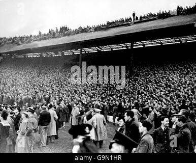 Una sezione dell'enorme folla di 85,000 persone si stette in campo mentre diverse centinaia di anime audaci, disperate nel vedere il laudito team di Dynamo Moscow, ottengono una vista elevata, anche se pericolosa, dal tetto dello stand Foto Stock