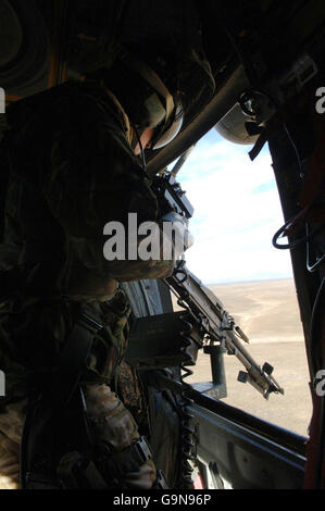 Un loadmaster guarda da un elicottero RAF Chinook come vola sull'Afghanistan. Foto Stock