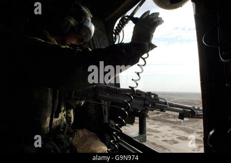 Un loadmaster guarda da un elicottero RAF Chinook mentre vola sull'Afghanistan. Foto Stock