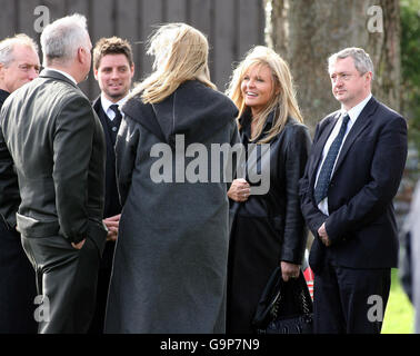 Il cantante statunitense Garth Brooks (seconda a sinistra) l'ex cantante Boyzone Keith Duffy (terza a sinistra) e il direttore commerciale della musica Louie Walsh (destra) al funerale del promotore di intrattenimento Jim Aiken presso la St Brigida's Church di Belfast. Foto Stock