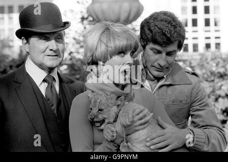 Joanna Lumley, che gioca a Purdey (al centro) con un cucciolo di leone di sei settimane Sulan e co-star Patrick MacNee, che interpreta John Steed, e Gareth Hunt, che interpreta Mike Gambit, ritratto durante le riprese ai Pinewood Studios Foto Stock