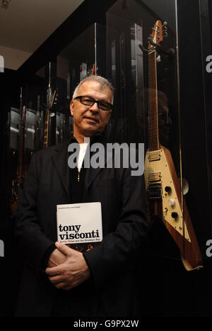 Il leggendario produttore di musica americano Tony Visconti si pone accanto ad una chitarra Hoyer Flying Arrow del 1970, suonata da Marc Bolan, durante una sessione di firma per il suo libro "Bowie, Bolan e The Brooklyn Boy", ad Harrods, nel centro di Londra. Foto Stock