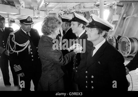 Il primo ministro Margaret Thatcher, che ha trascorso 80 minuti a bordo di HMS Hermes, mentre navigava a Portsmouth, inquadra una lunga medaglia di servizio sul petto di un ufficiale, mentre il capitano Lynn Middleton guarda. Foto Stock