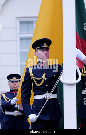 Membri del lituano di Air Force o LAF l aviazione militare ramo del lituano di forze armate alzando bandiera nazionale durante la modifica delle protezioni cerimonia di fronte al palazzo presidenziale nella città vecchia di Vilnius, capitale della Lituania Foto Stock