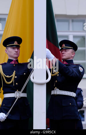 Membri dell'aeronautica lituana o LAF il ramo dell'aviazione militare delle forze armate lituane solleva la bandiera nazionale lituana durante la cerimonia del cambio di guardia di fronte al palazzo presidenziale nella città vecchia di Vilnius, la capitale della Lituania Foto Stock