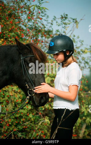 Ragazza con cavallo islandese / casco, equitazione casco Foto Stock