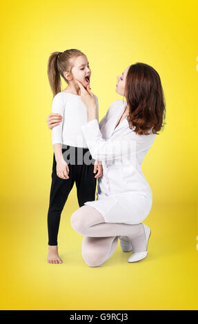 Medico di esaminare la gola della bambina Foto Stock