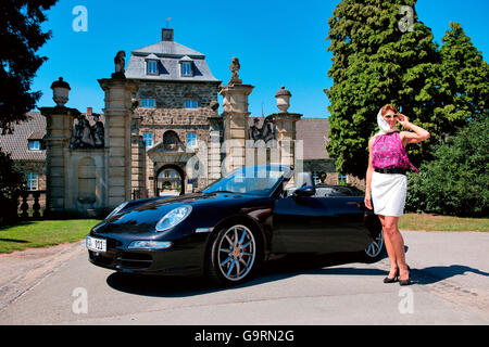 Donna elegante e Porsche 911 nella parte anteriore del castello, 911 carrera, 4S, autovettura convertibile, sportscar, lussuoso Foto Stock