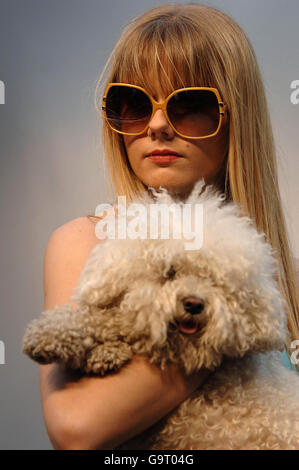 Un modello che indossa abiti della collezione 'Paris Hilton Inspired' di Victoria McBryde, cammina sulla passerella con un cane durante la Swatch alternative Fashion Week allo Spitalfields Traders Market nella parte est di Londra. Foto Stock