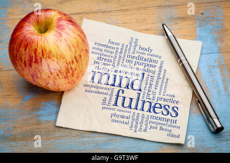 Mindfulness word cloud su un tovagliolo con un fresco apple Foto Stock