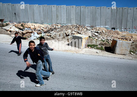 I bambini giocano vicino alla barriera della Cisgiordania israeliana a Gerusalemme. Foto Stock