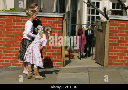 Maddie Gainer, 5 anni, con le sue sorelle Natasha, 10 anni, e Abigail, 8, si intravedono intorno al muro per dare un'occhiata alla regina Elisabetta II e al duca di Edimburgo mentre lasciano il servizio della domenica di Pasqua nella cappella di San Giorgio, Castello di Windsor. Foto Stock