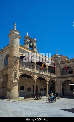 Cittadino in una motocicletta attraversando la parte anteriore della facciata principale del Municipio, in piazza Mayor di Ciudad Rodrigo, Salamanca. Spagna. Foto Stock