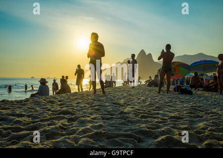 RIO DE JANEIRO - Febbraio 21, 2016: Beachgoers stop per prendere il tramonto sulla spiaggia di Ipanema, celebrato con un applauso. Foto Stock