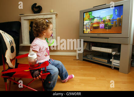 Maisy Byrne, 2 anni, guarda i programmi dei suoi bambini preferiti in televisione a casa sua a Merseyside. Foto Stock