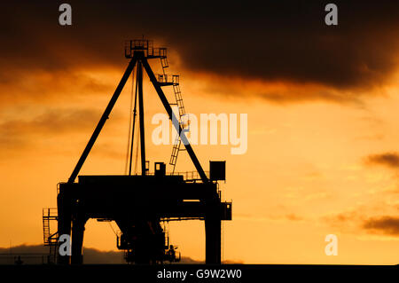 Silhouette drammatico di lifting Gantry birkenhead docks al tramonto Foto Stock