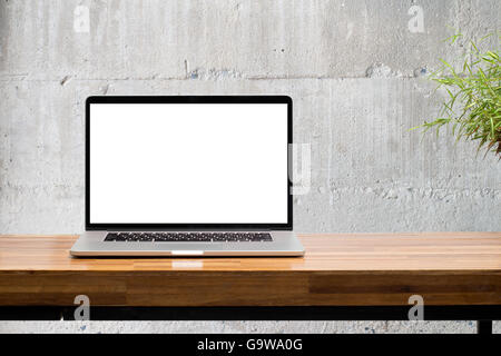 Computer portatile schermata vuota sul tavolo di legno con parete di cemento sullo sfondo Foto Stock