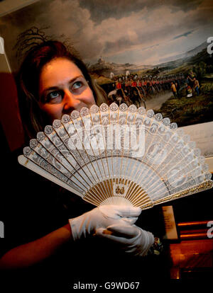 L'assistente Sabrina MacKenzie si pone con un fan di ivory brise del 1863, un regalo alla principessa Alexandra di Danimarca, in una mostra al Castello di Windsor, nel Berkshire. Foto Stock