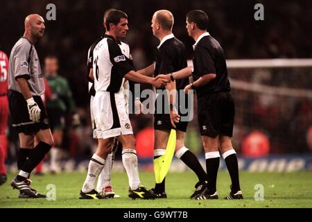 Il capitano del Manchester United Roy Keane (c) scuote le mani con l'arbitro Andy D'Urso (r) come portiere Fabien Barthez (l) aspetta lamentarsi Foto Stock