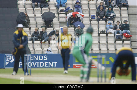 Gli spettatori si rifugiano dal frizzle e dalla pioggia durante la partita dell'Hampshire contro l'Irlanda nel Friends Provident Trophy al Rose Bowl di Southampton. Foto Stock