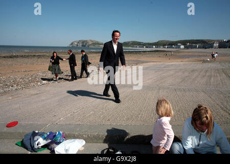 Il leader del Partito conservatore David Cameron durante una passeggiata sulla spiaggia di Llandudno durante la campagna elettorale del Partito conservatore. Foto Stock