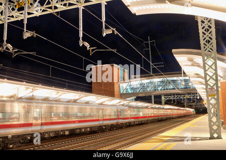 Motion Blur immagine del treno accelerando attraverso la stazione della metropolitana di notte Foto Stock