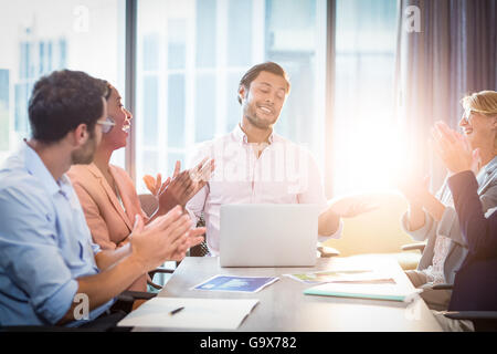 I colleghi ad applaudire un collega dopo la presentazione Foto Stock