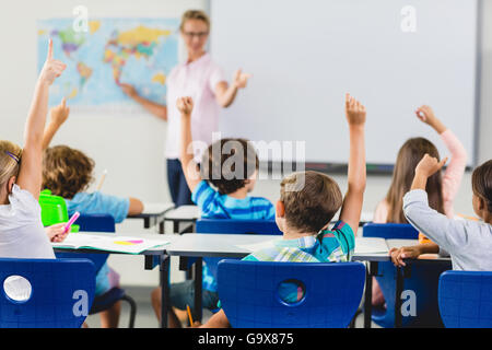 Kids alzando la mano in aula Foto Stock