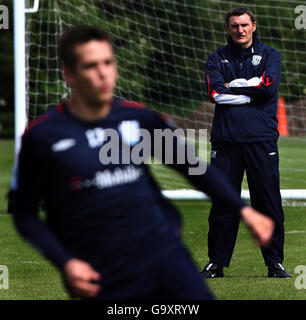 Il manager di West Bromwich Albion Tony Mowbray guarda i suoi giocatori durante una sessione di allenamento al loro campo di allenamento a West Bromwich. Foto Stock