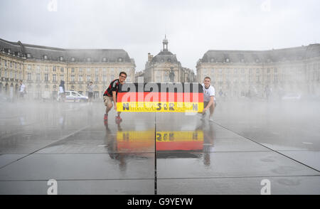 Bordeaux, Francia. 02Giugno, 2016. I tifosi tedeschi Niklas (L) e Robin tenere una bandiera tedesca a Place de la Bourse di Bordeaux, Francia, 02 giugno 2016. La Germania dovrà affrontare in Italia la UEFA Euro 2016 quarterfinal match stasera a Bordeaux. Foto: Arne Dedert/dpa/Alamy Live News Foto Stock