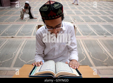 Peshawar. 4 Luglio, 2016. Un uomo legge il santo Corano in una moschea durante il Ramadan nel nord-ovest del Pakistan Peshawar il 4 luglio 2016. © Ahmad Sidique/Xinhua/Alamy Live News Foto Stock