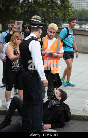 Londra, Regno Unito. 4 Luglio, 2016. Un uomo di polizia impedire anarchico e manifestanti dal blocco del traffico durante uno sciopero generale dopo Brexit e contro il governo conservatore a Lambeth Bridge. Credito: Thabo Jaiyesimi/Alamy Live News Foto Stock
