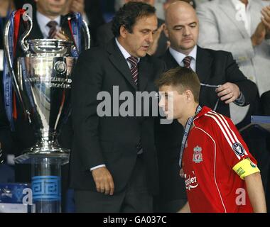 Il presidente della UEFA Michel Platini (al centro) console il capitano di Liverpool Steven Gerrard (a destra) mentre cammina oltre il trofeo dopo il gioco. Foto Stock