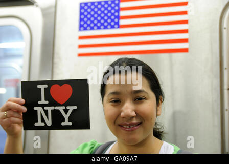 Latino donna tenendo un amo New York cartolina, metropolitana treno, metro, New York New York, Stati Uniti d'America Foto Stock