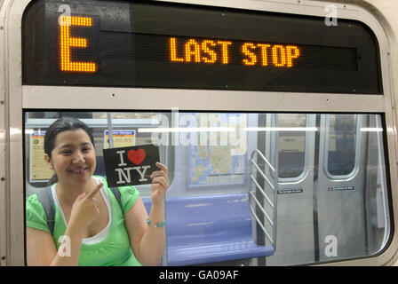 Latino donna azienda io amo New York cartolina, la metropolitana, la stazione della metropolitana, ultima fermata, New York New York, Stati Uniti d'America Foto Stock