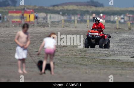 Un bagnino in quad si snoda lungo Dollymount Strand, Dublino, che non è riuscito a garantire l'ambita Bandiera Blu per l'eccellenza ambientale. Foto Stock