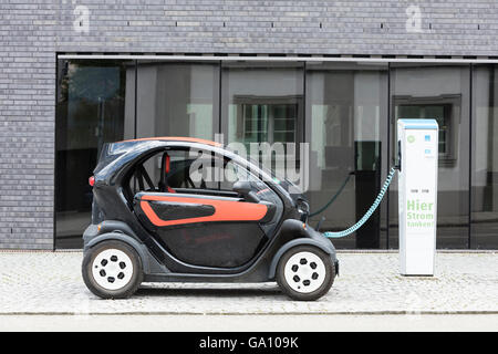 Auto elettrica, Renault, essere ricaricati a plug-in stazione di fronte all ufficio moderno edificio. Foto Stock