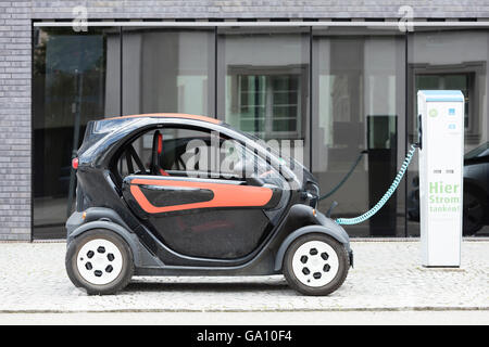 Auto elettrica, Renault, essere ricaricati a plug-in stazione di fronte all ufficio moderno edificio. Foto Stock