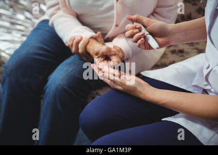 L'infermiera aiutando senior donna con diabete Foto Stock