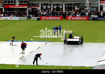 Cricket - Twenty20 Cup - North Division - Leicestershire Foxes / Durham dinamos - Grace Road. Gli imperi osservano che il personale della terra cerca di sgombrare l'acqua dalle coperture prima della partita della Twenty20 Cup a Grace Road, Leicester. Foto Stock