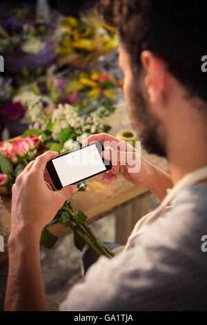 Fioraio maschio tenendo fotografia di mazzo di fiori Foto Stock